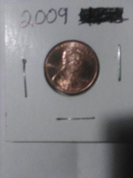 2009 us penny man sitting on log on…