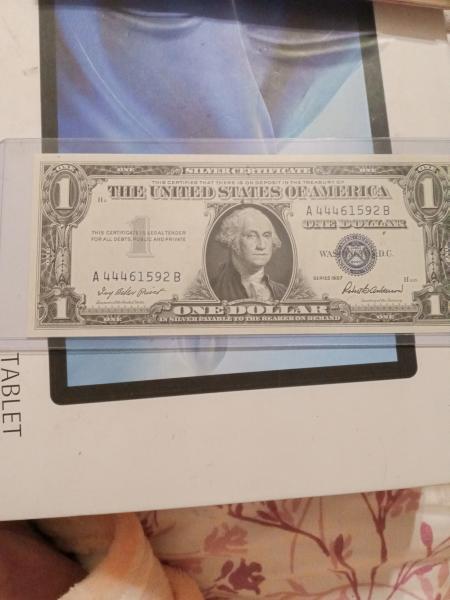 A one dollar silver certificate with the serial…